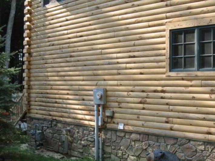 The same log home wall after corn cob blasting, with clean, light wood